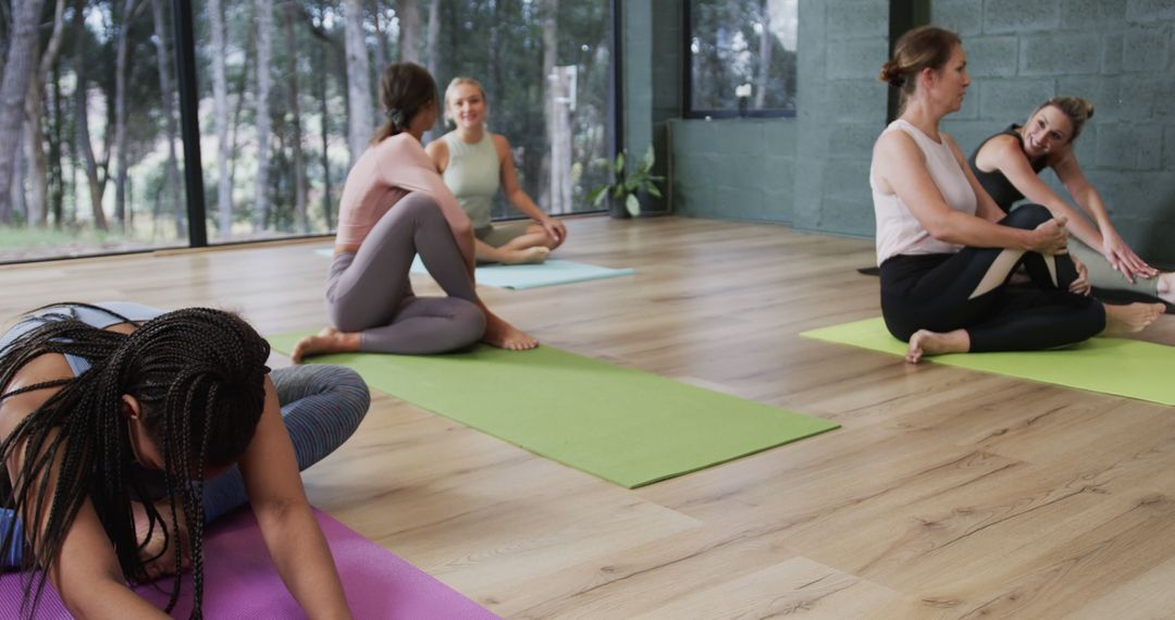 Women Practicing Yoga Together in a Studio with Wooden Floor - Free Images, Stock Photos and Pictures on Pikwizard.com