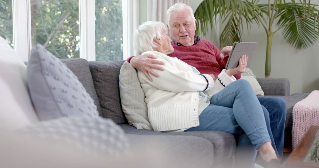 Happy Senior Couple Relaxing at Home Using Tablet