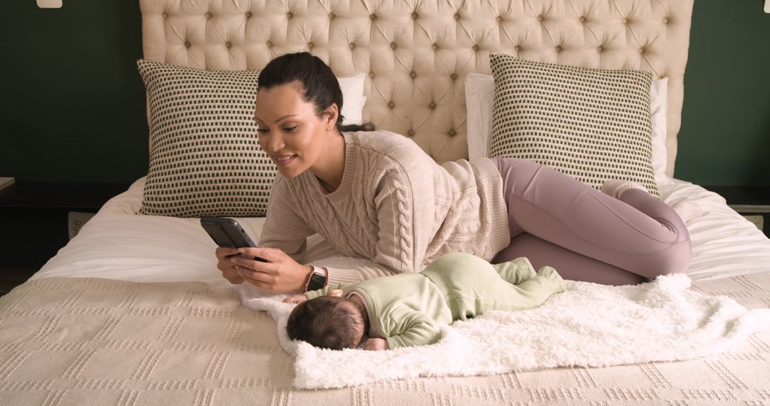 Mother Engaging with Technology While Baby Sleeps Peacefully