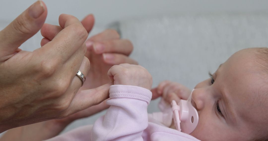 Baby Holding Parent's Hand, Pacifier in Mouth - Free Images, Stock Photos and Pictures on Pikwizard.com