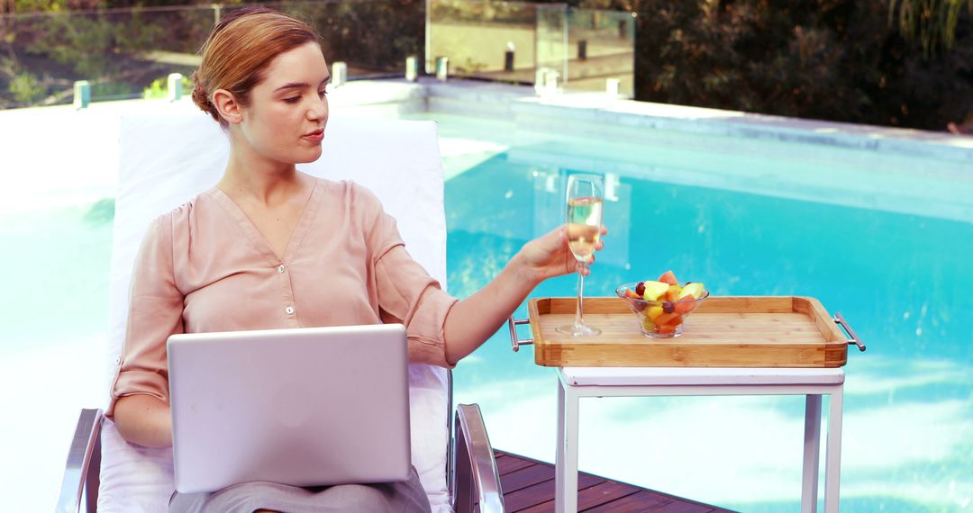 Woman Remote Working by Pool with Laptop and Refreshments - Free Images, Stock Photos and Pictures on Pikwizard.com