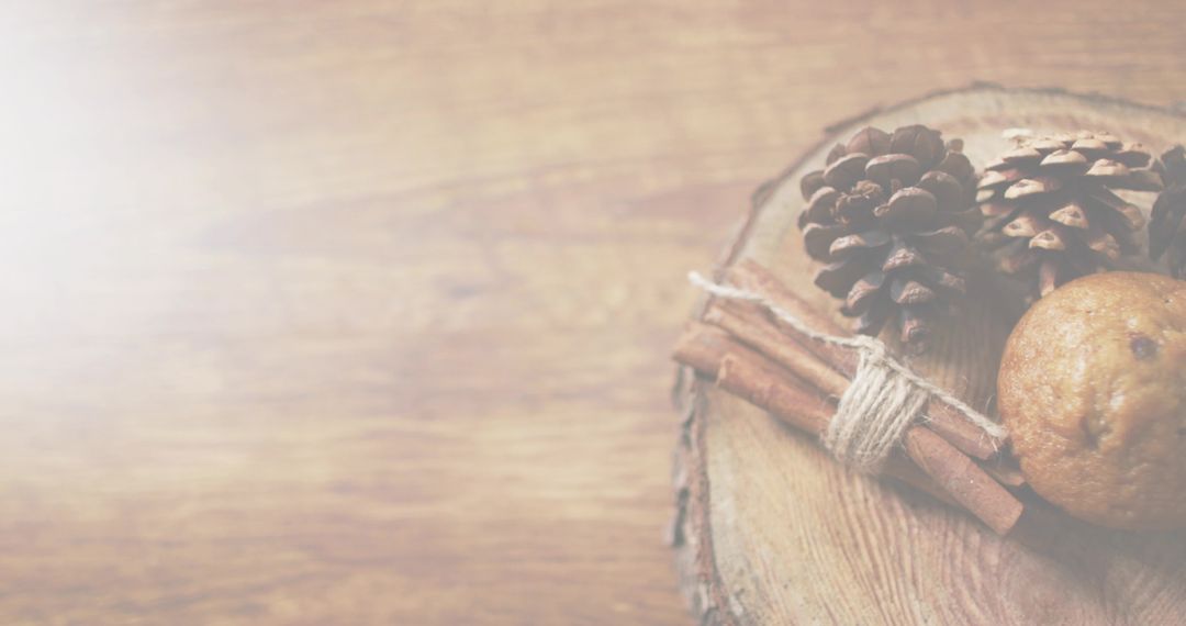 Rustic autumn vignette with pinecones, twine-tied cinnamon sticks and cookie on wood slice