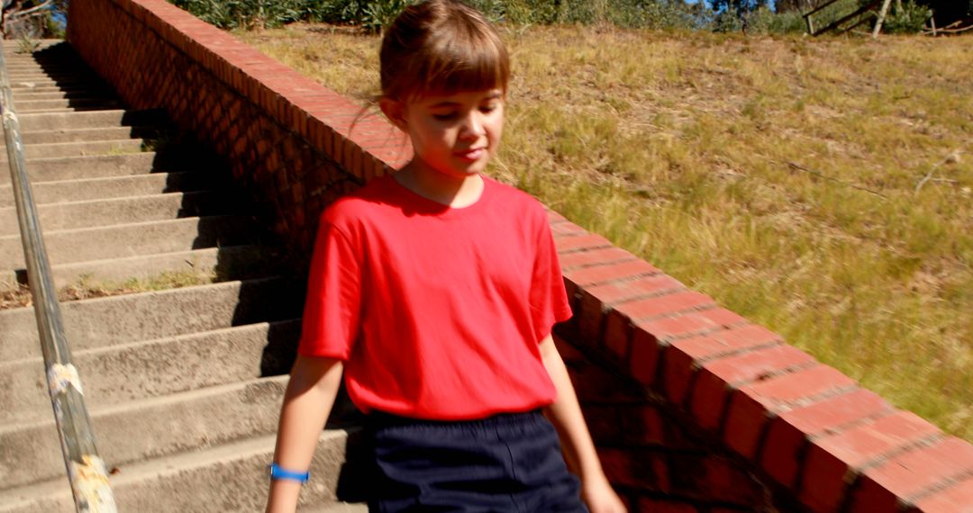 Young Boy Walking Down Sunny Outdoor Stairs in Casual Outfit - Free Images, Stock Photos and Pictures on Pikwizard.com