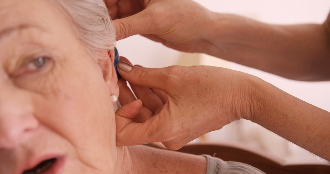 Caregiver Placing Hearing Aid on Elderly Woman - Free Images, Stock Photos and Pictures on Pikwizard.com