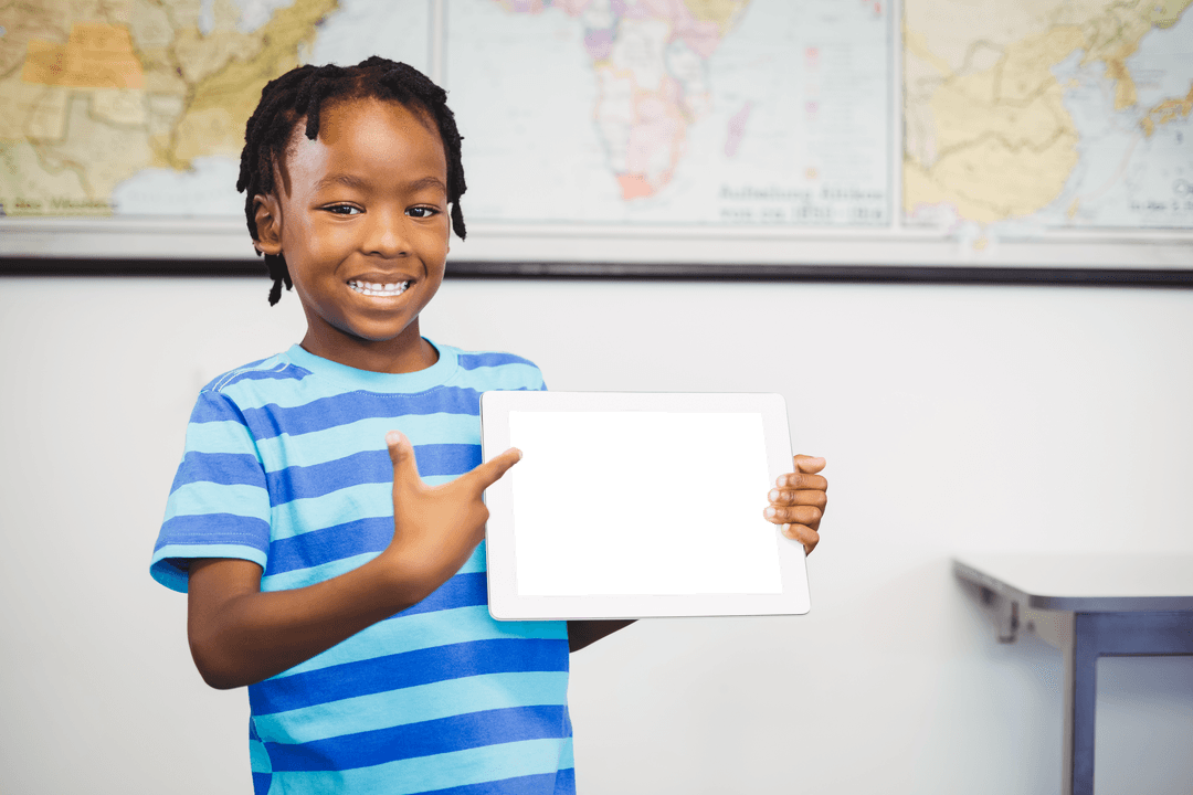 Smiling Boy Pointing at Blank Tablet in Classroom with Map