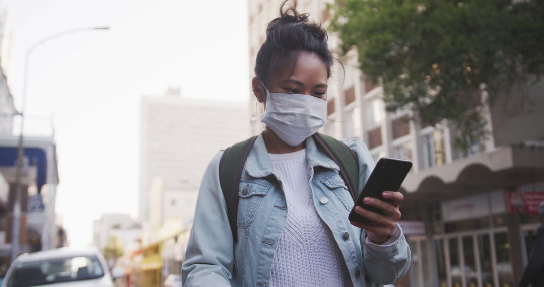 Young Woman Wearing Mask Using Smartphone Outdoors - Free Images, Stock Photos and Pictures on Pikwizard.com