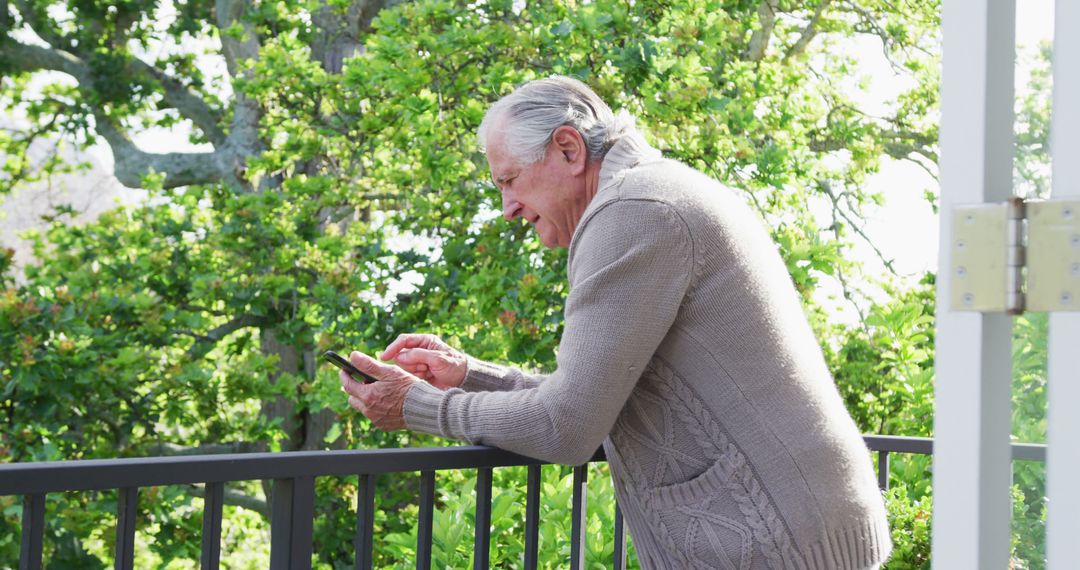 Elderly Man Using Smartphone on Balcony - Free Images, Stock Photos and Pictures on Pikwizard.com