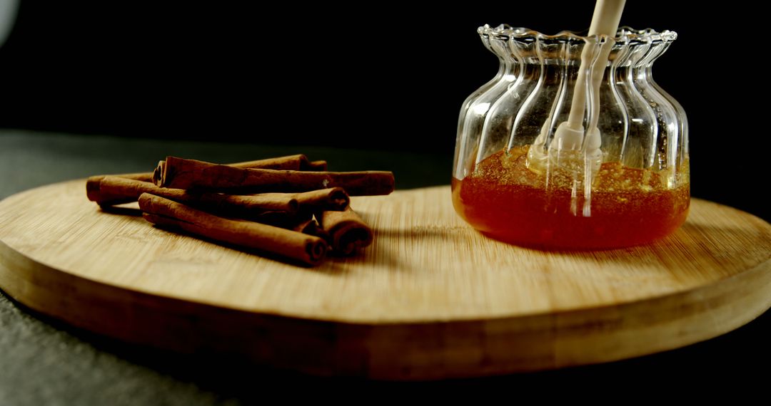 Honey Jar and Cinnamon Sticks on Wooden Board with Dark Background - Free Images, Stock Photos and Pictures on Pikwizard.com