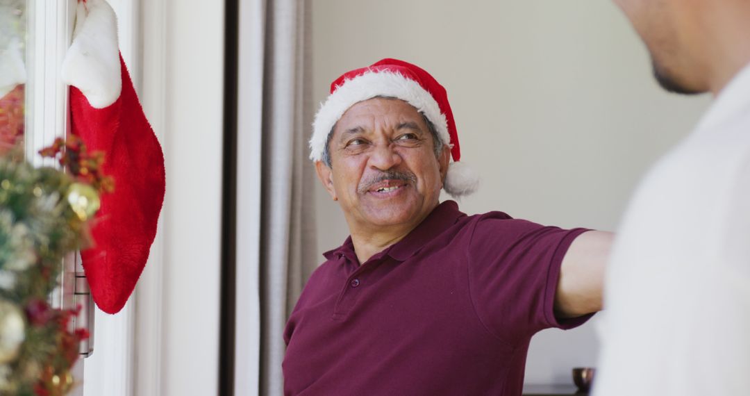 Man in Santa Hat Welcoming Guests During Christmas - Free Images, Stock Photos and Pictures on Pikwizard.com