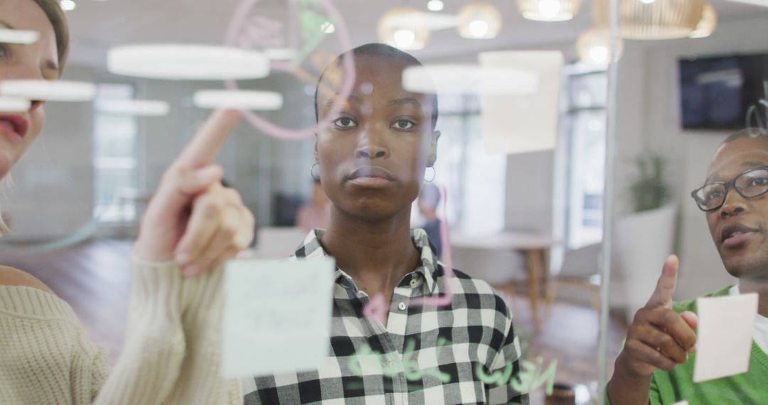 Diverse Team Brainstorming with Memo Notes on Glass Wall