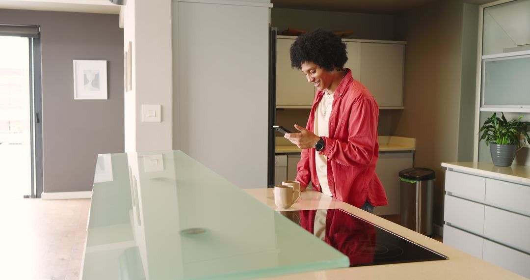 Man Engaging with Smartphone in Minimalist Home Kitchen