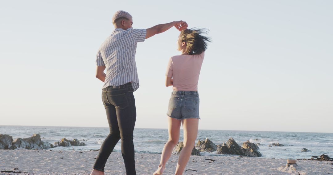 Happy diverse couple dancing on beach at sunset - Free Images, Stock Photos and Pictures on Pikwizard.com