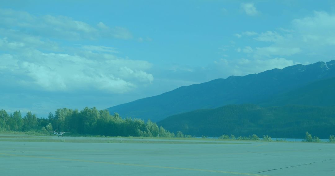 Small Airplane on Runway Near Mountain and Lake Scenery