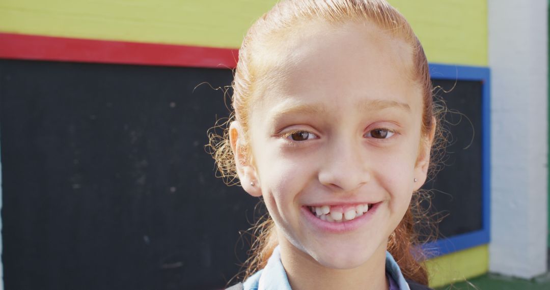 Joyful Schoolgirl Smiling in Playground Setting