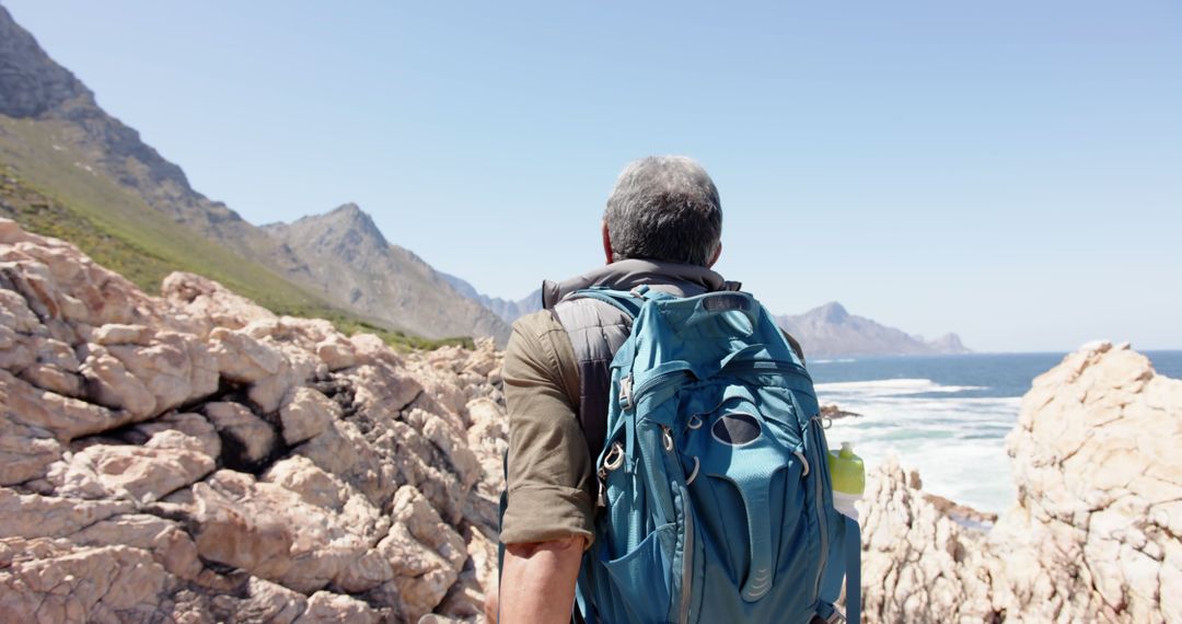 Senior Man Hiking Adventure by Seaside with Blue Backpack