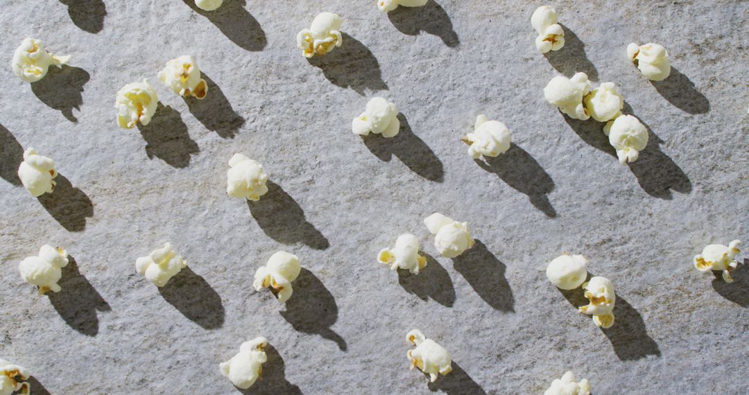 Popcorn Scattered on Gray Surface with Shadows
