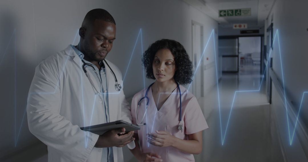 Doctors discussing patient charts in hospital hallway - Free Images, Stock Photos and Pictures on Pikwizard.com