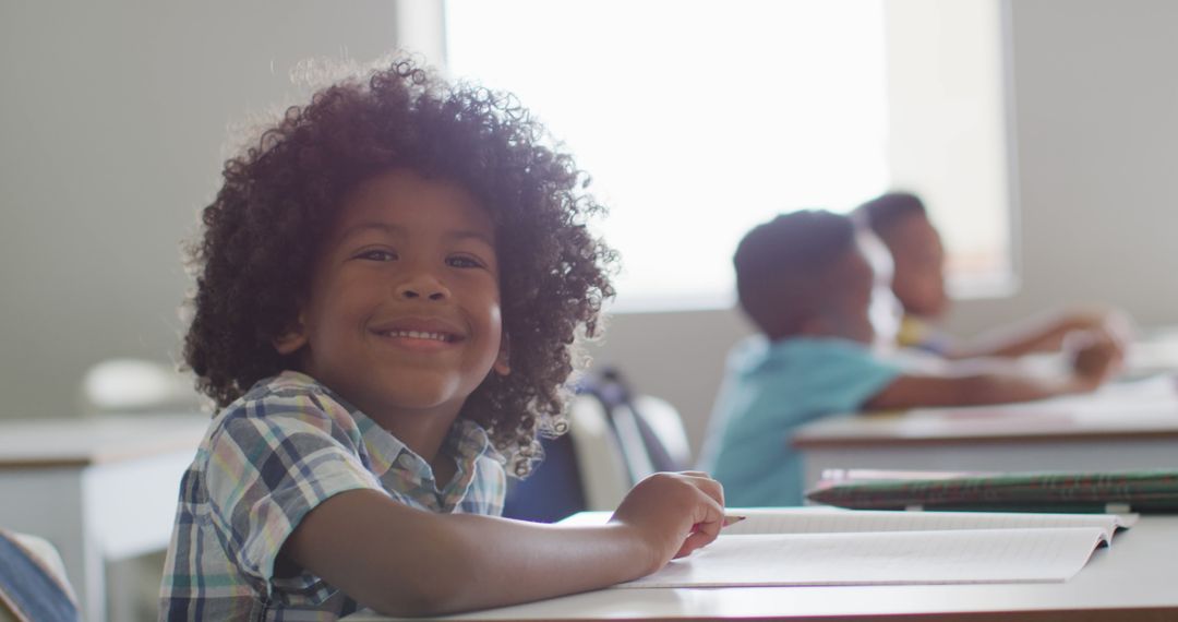 Smiling Young Boy in Classroom with Classmates in Background