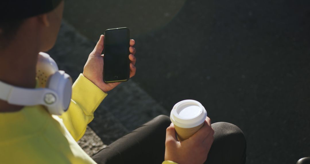 Person Relaxing with Smartphone and Coffee Cup Outdoors - Free Images, Stock Photos and Pictures on Pikwizard.com