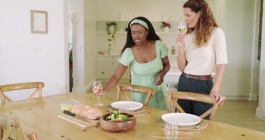 Friends Preparing Table with Wine and Bread at Home Gathering