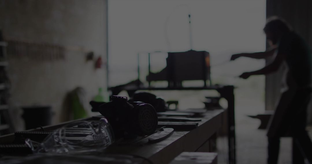Skilled Metalworker Using Tools in Dimly Lit Workshop