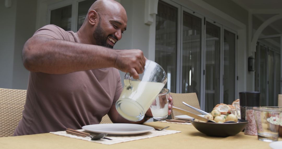 Man Pouring Lemonade at Outdoor Dining Table - Free Images, Stock Photos and Pictures on Pikwizard.com