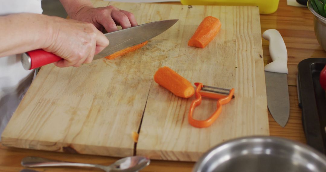 Chef chopping fresh carrots in kitchen with knives and peeler - Free Images, Stock Photos and Pictures on Pikwizard.com