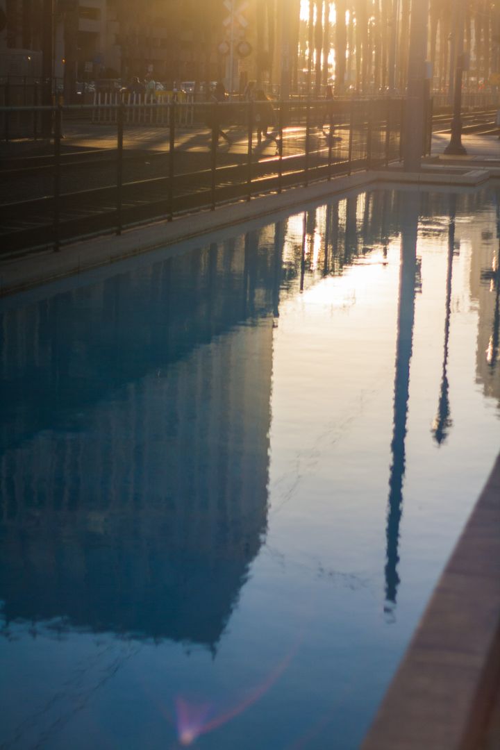 Cityscape Reflected in Pool with Golden Sunset - Free Images, Stock Photos and Pictures on Pikwizard.com