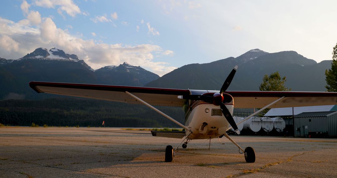 Small Airplane Parked on Runway with Mountain Background at Sunset - Free Images, Stock Photos and Pictures on Pikwizard.com