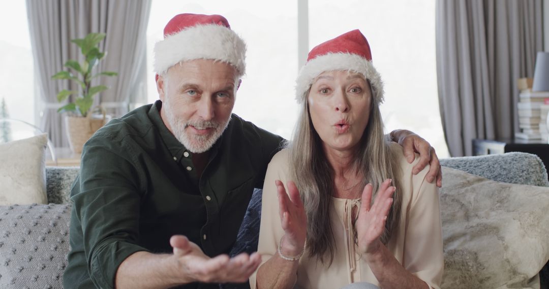 Joyful Couple with Santa Hats Celebrating Christmas Online - Free Images, Stock Photos and Pictures on Pikwizard.com