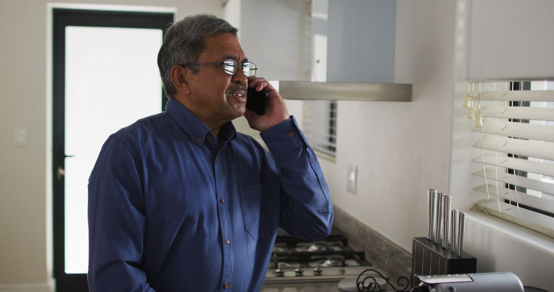 Smiling Man Senior Talking on Phone in Modern Bright Kitchen - Free Images, Stock Photos and Pictures on Pikwizard.com