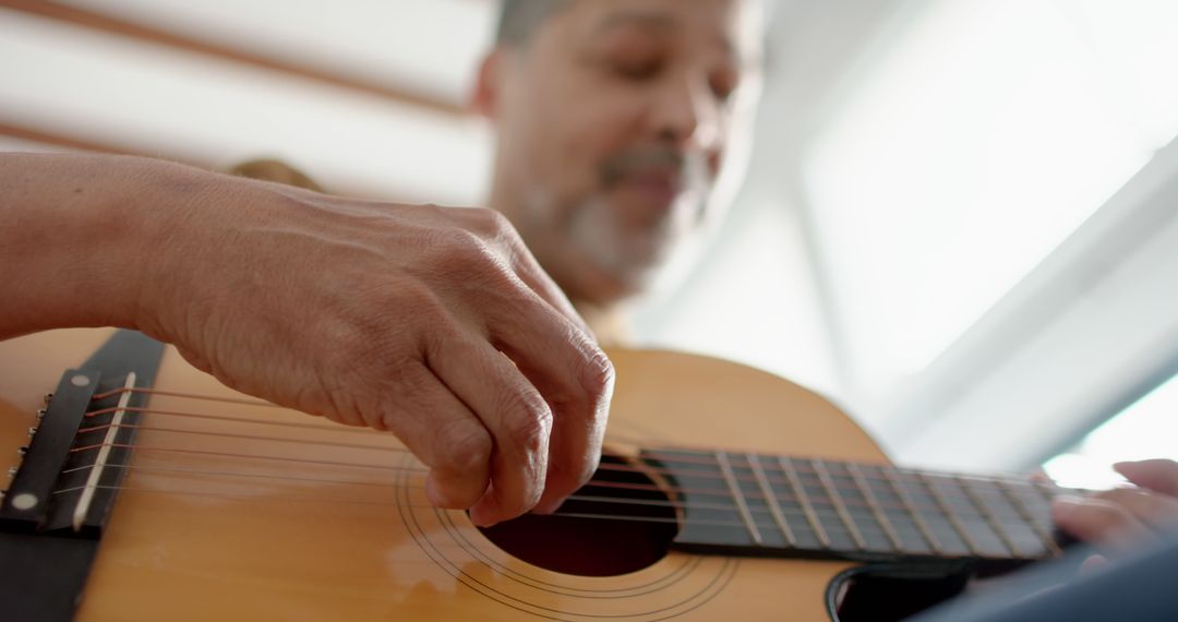 Close-Up of Mature Man Playing Acoustic Guitar Indoors - Free Images, Stock Photos and Pictures on Pikwizard.com