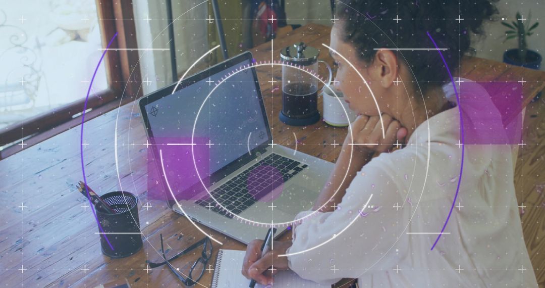 Focused Woman Analyzing Data on Laptop with Note-taking