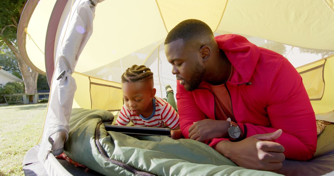 Father and Son Bonding in Tent with Tablet Outdoors - Free Images, Stock Photos and Pictures on Pikwizard.com