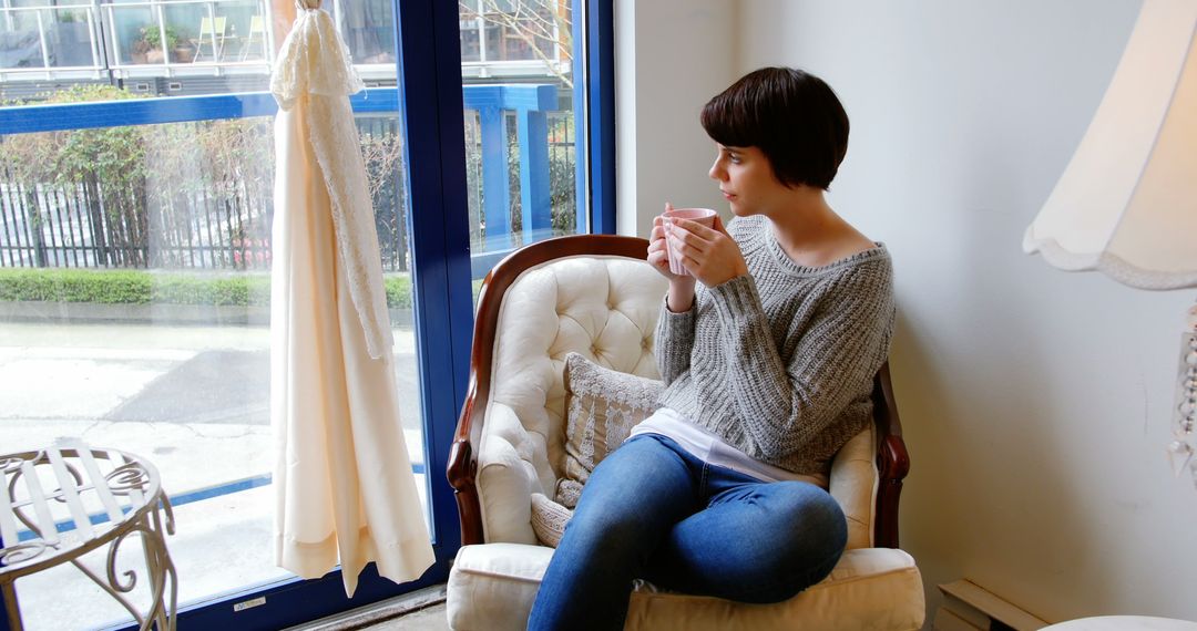 Woman Relaxing Indoors with Coffee Looking Through Window - Free Images, Stock Photos and Pictures on Pikwizard.com