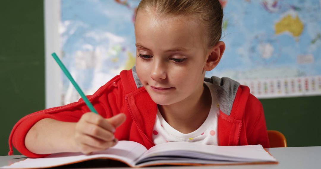 Young girl writing in notebook in classroom with map background - Free Images, Stock Photos and Pictures on Pikwizard.com