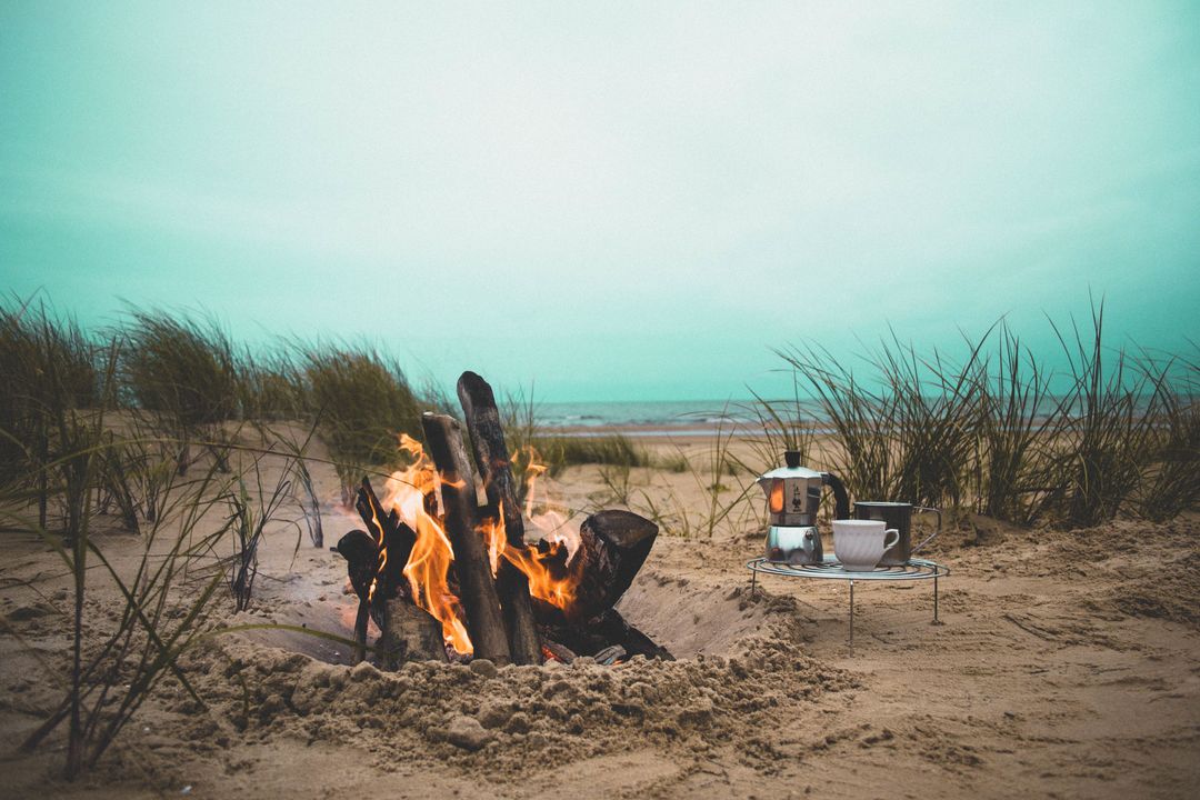 Campfire on Tranquil Beach with Coffee Setup