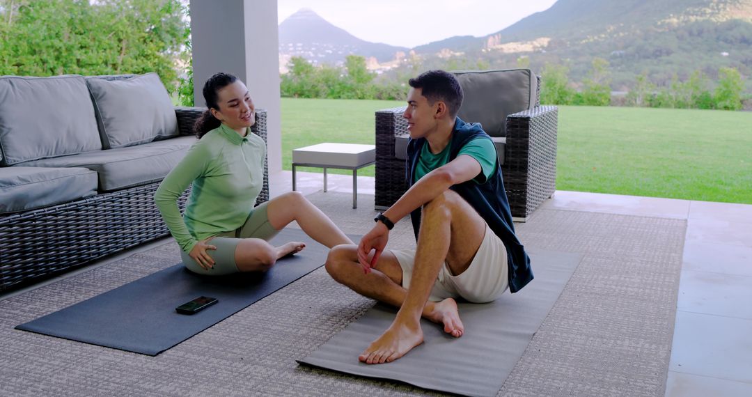 Diverse Group Relaxing on Patio After Workout with Technology