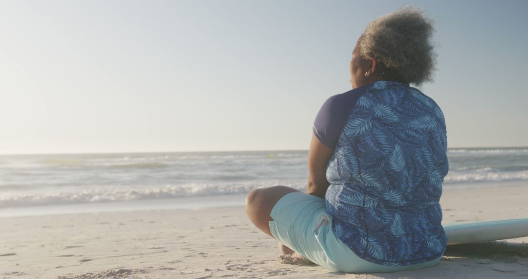 Senior Woman Relaxing on Sandy Beach at Sunset - Free Images, Stock Photos and Pictures on Pikwizard.com