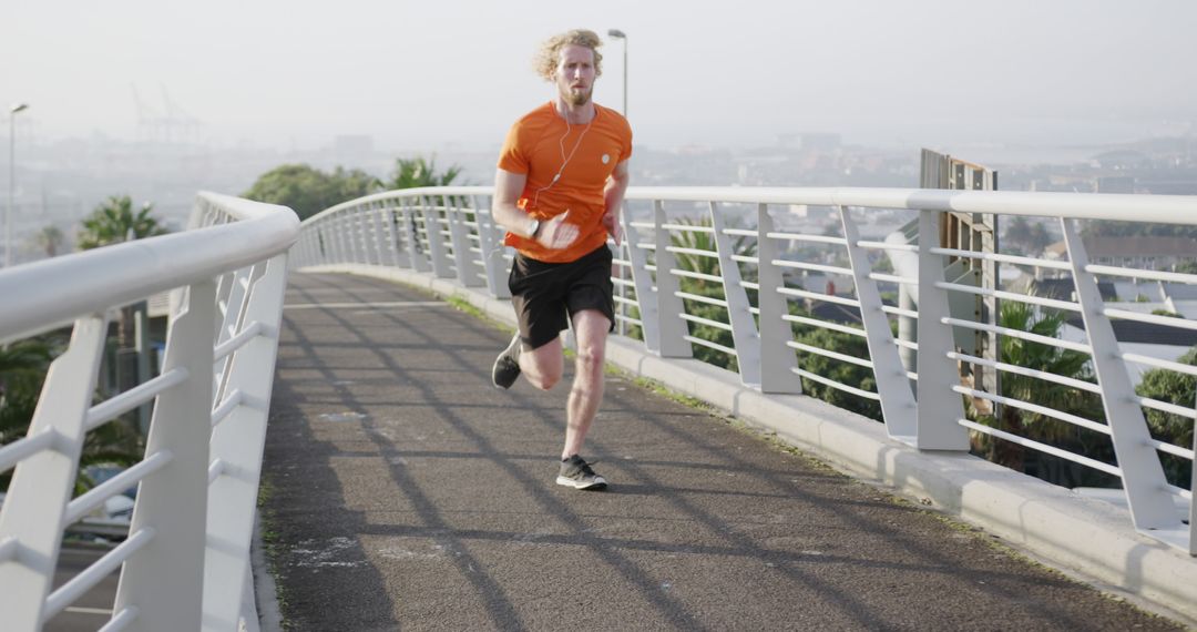 Young Man Jogging on Urban Bridge in Morning Light - Free Images, Stock Photos and Pictures on Pikwizard.com