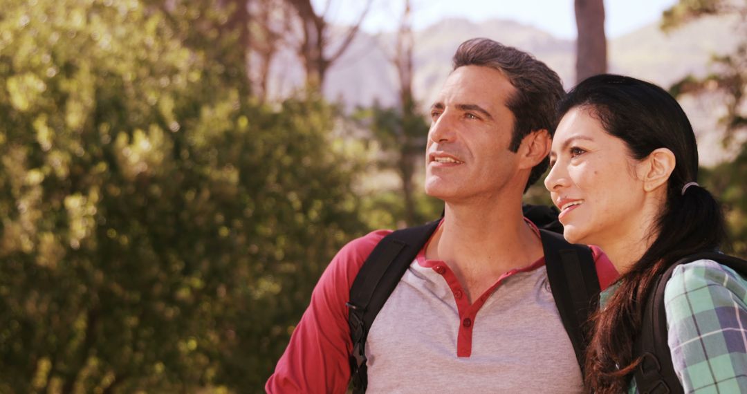 Smiling Couple Enjoying Outdoor Hike in Sunlit Forest - Free Images, Stock Photos and Pictures on Pikwizard.com