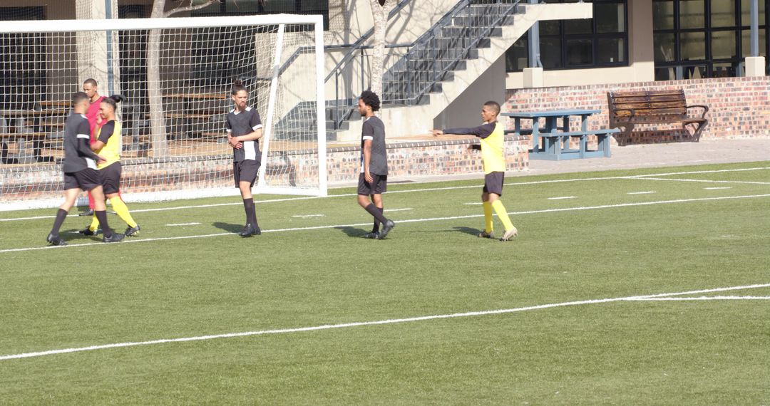 Soccer Players Discussing Strategy Near Goal During Practice