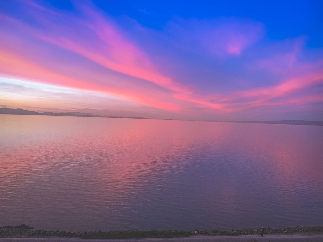 Stunning Sunset Over Calm Water Reflecting Colorful Sky - Free Images, Stock Photos and Pictures on Pikwizard.com