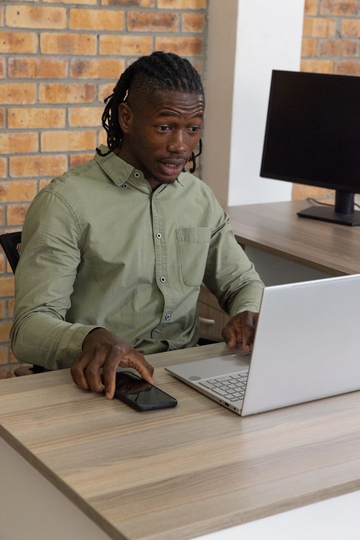Professional Man Communicating While Working on Laptop at Office Desk
