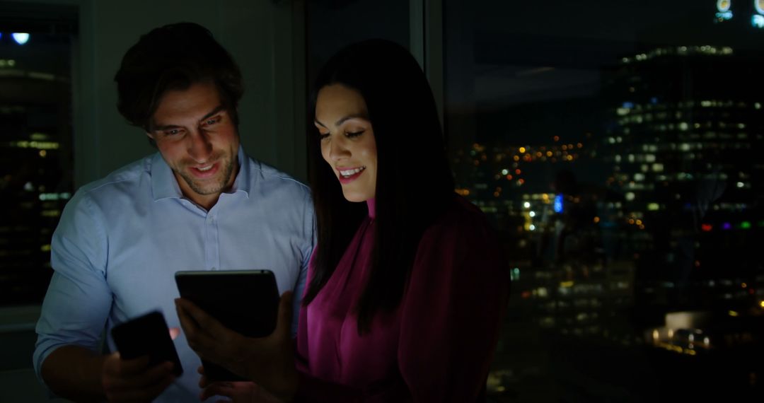 Smiling Office Executives Discussing Over Tablet at Night