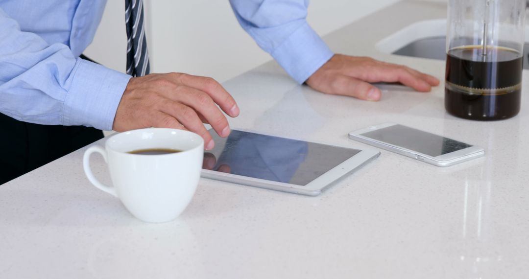 Businessman Using Tablet and Smartphone While Having Coffee - Free Images, Stock Photos and Pictures on Pikwizard.com