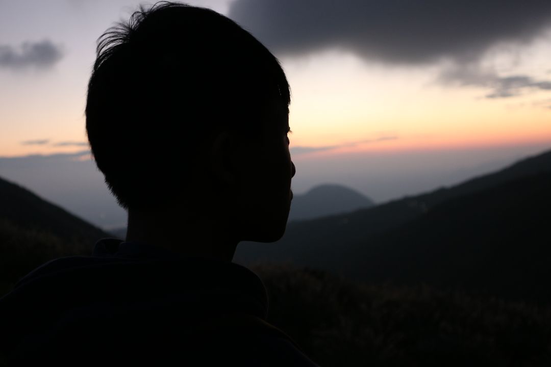 Silhouette of Boy Watching Sunset on Mountain - Free Images, Stock Photos and Pictures on Pikwizard.com