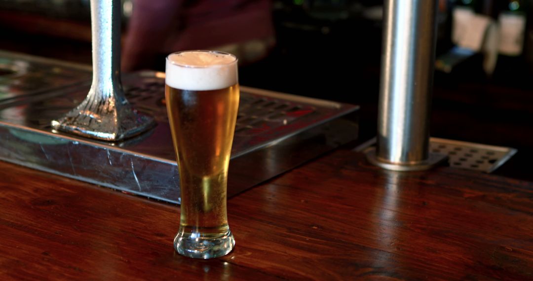 Glass of Draft Beer on Bar Counter in Cozy Pub Ambiance