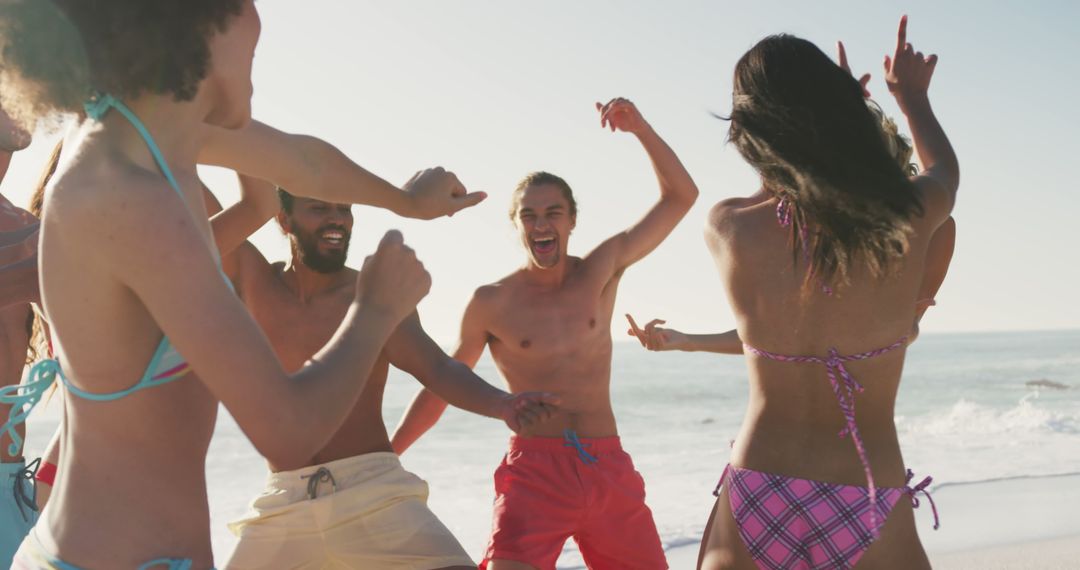 Group of Friends Joyfully Dancing on Sunny Beach - Free Images, Stock Photos and Pictures on Pikwizard.com