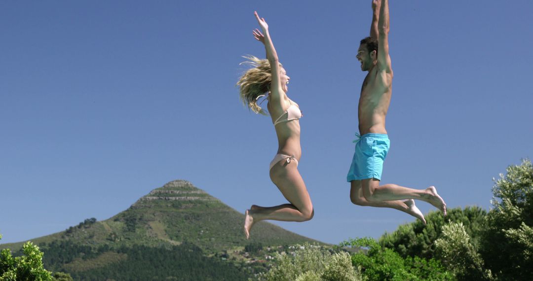 Happy Couple Jumping in Air Near Mountain - Free Images, Stock Photos and Pictures on Pikwizard.com